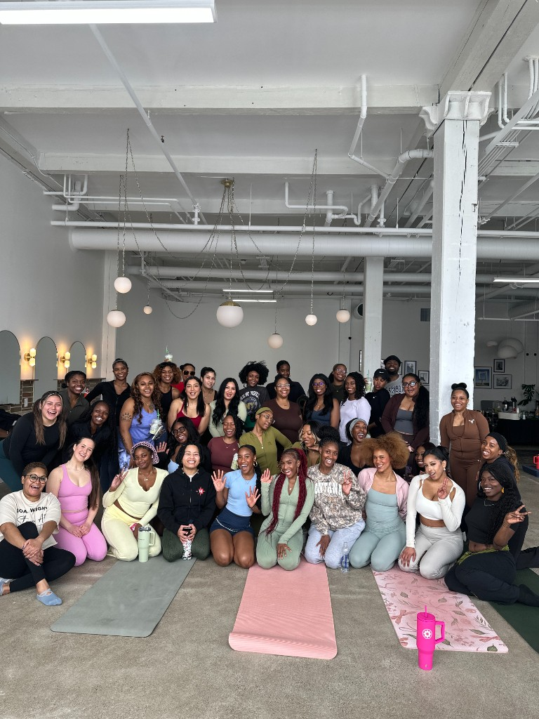 Community class group photo in a bright Pilates studio