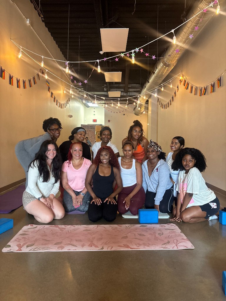 Community group posing together in a studio with string lights