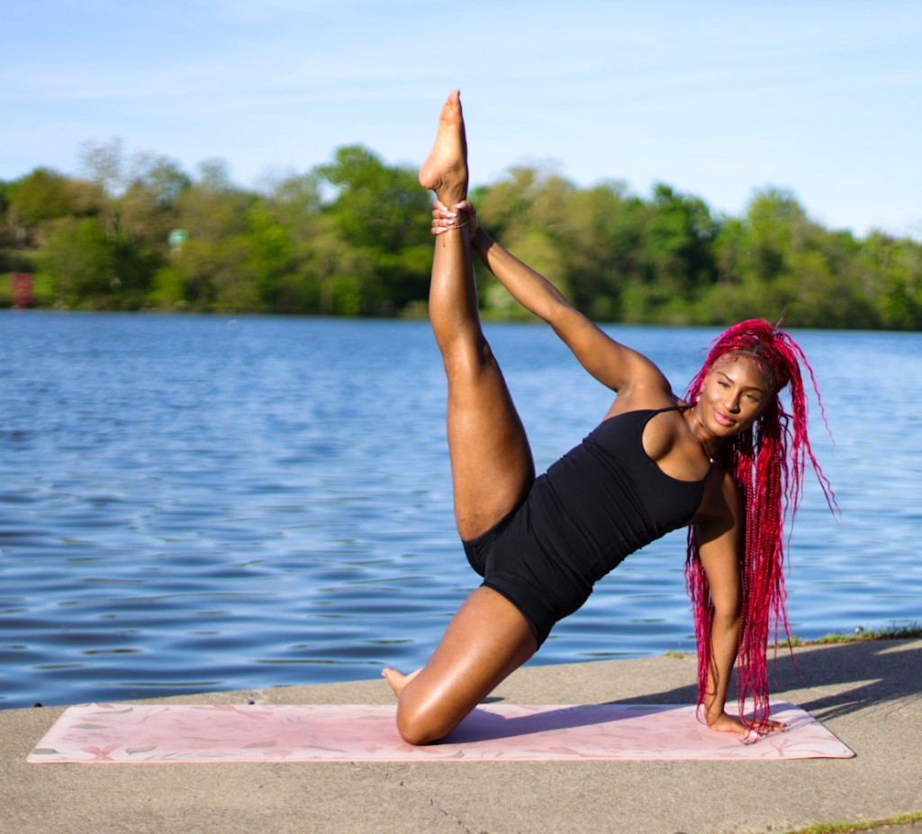 Nellé Mignon in a side stretch pose outdoors by the water